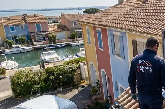 Maisons colorées et bateaux sur un canal de Martigues vus depuis un chantier de toiture en tuiles canal